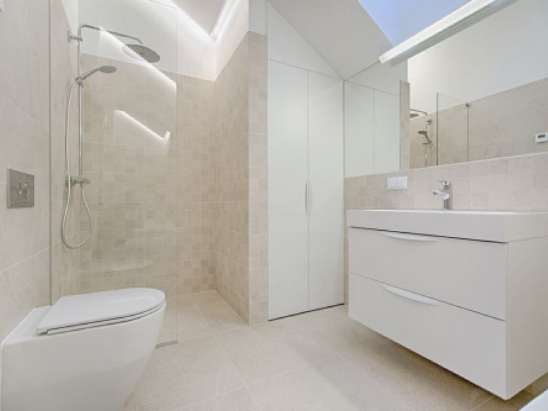 Baño con paredes claras y sanitarios de color blanco